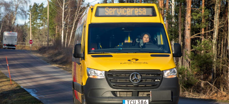 Kalmar länstrafiks gul/röda minibuss på landsväg.