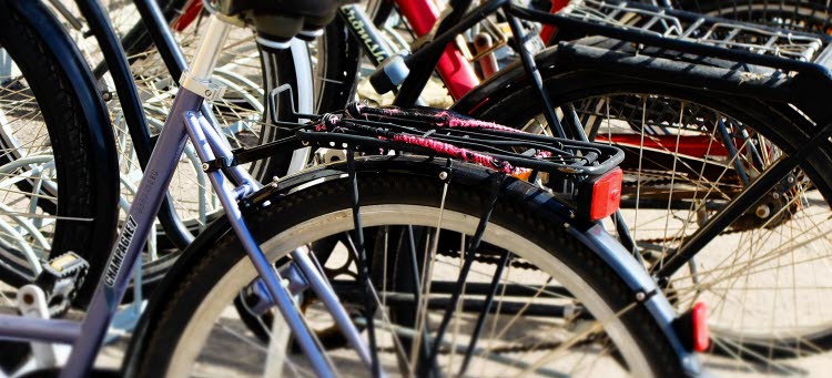 Flera cyklar som är parkerade vid ett cykelställ