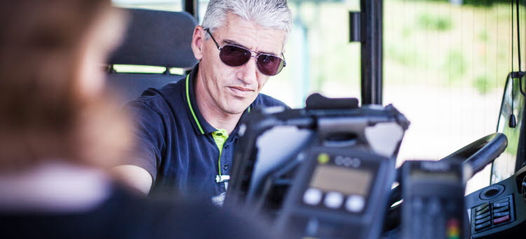 En busschaufför som välkomnar en resenär