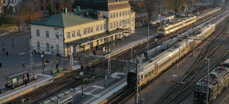 Drönarbild på Kalmar C. Tre tåg som står uppställda framför stationshuset i Kalmar.