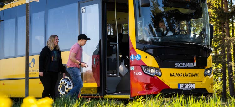Två resenärer går ombord via framdörren på en buss