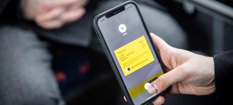 En person håller i en mobil. På mobilen syns en enkelbiljett hos Kalmar länstrafik.
